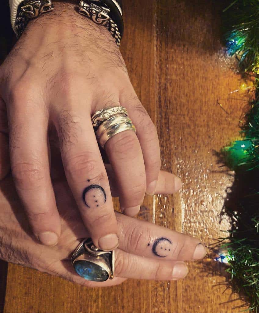 Middle fingers with crescent moon tattoos