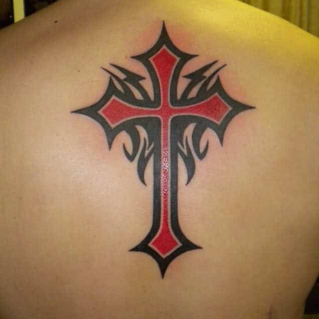 Back tattoo of a red cross with black tribal flame-like accents