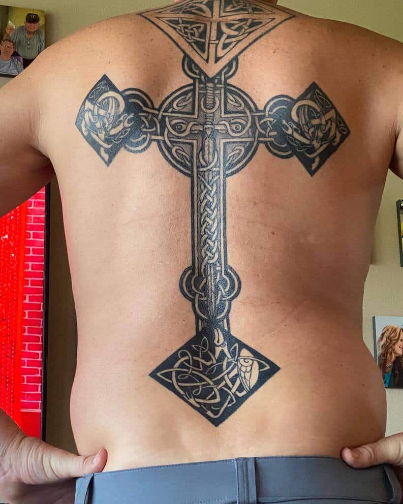 A back tattoo showcasing a grand Celtic cross with elaborate knot patterns