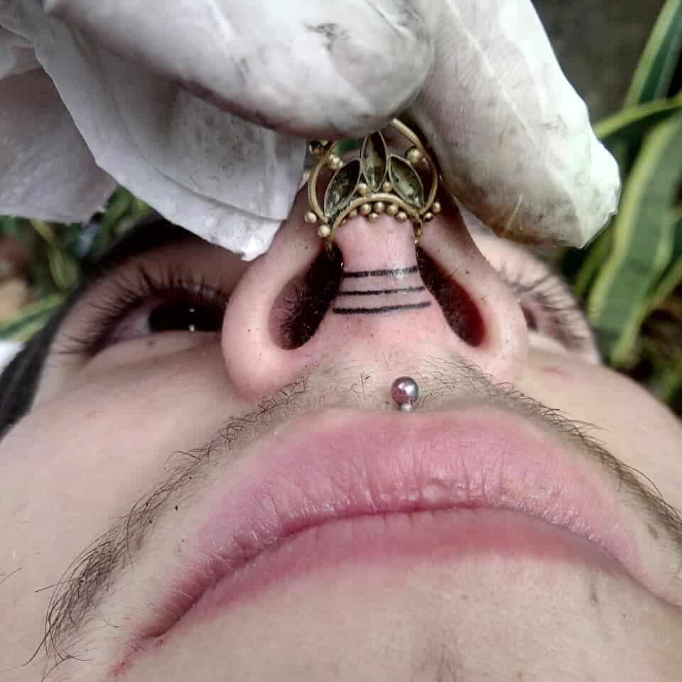 Three lines tattoo between the nostrils