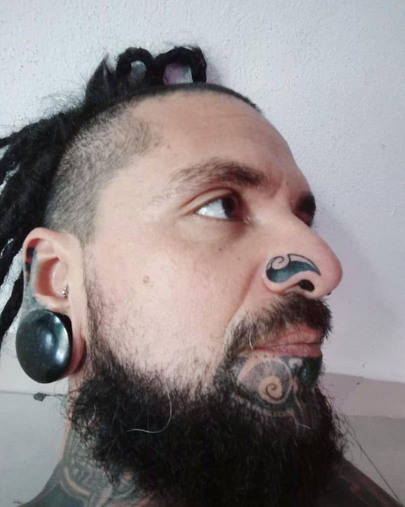 Man with a bold swirl tattoo on his nose