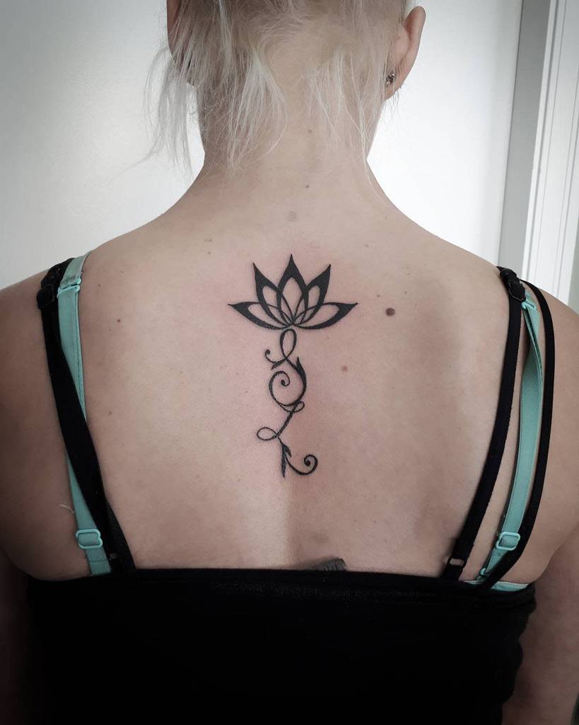 Woman with a lotus flower tattoo on her upper back