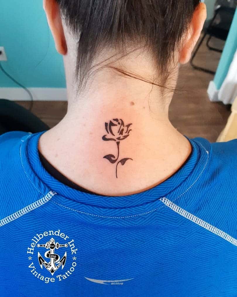 Small, black rose tattoo on the back of their neck in a tribal style