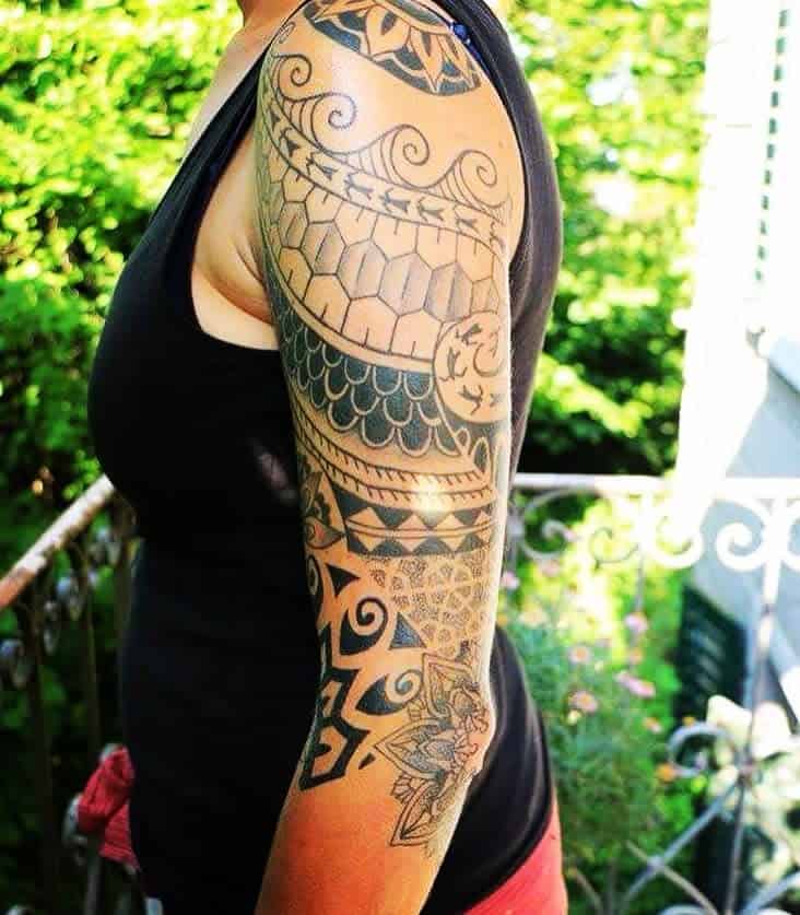 Woman with a full sleeve tattoo featuring geometric and tribal patterns