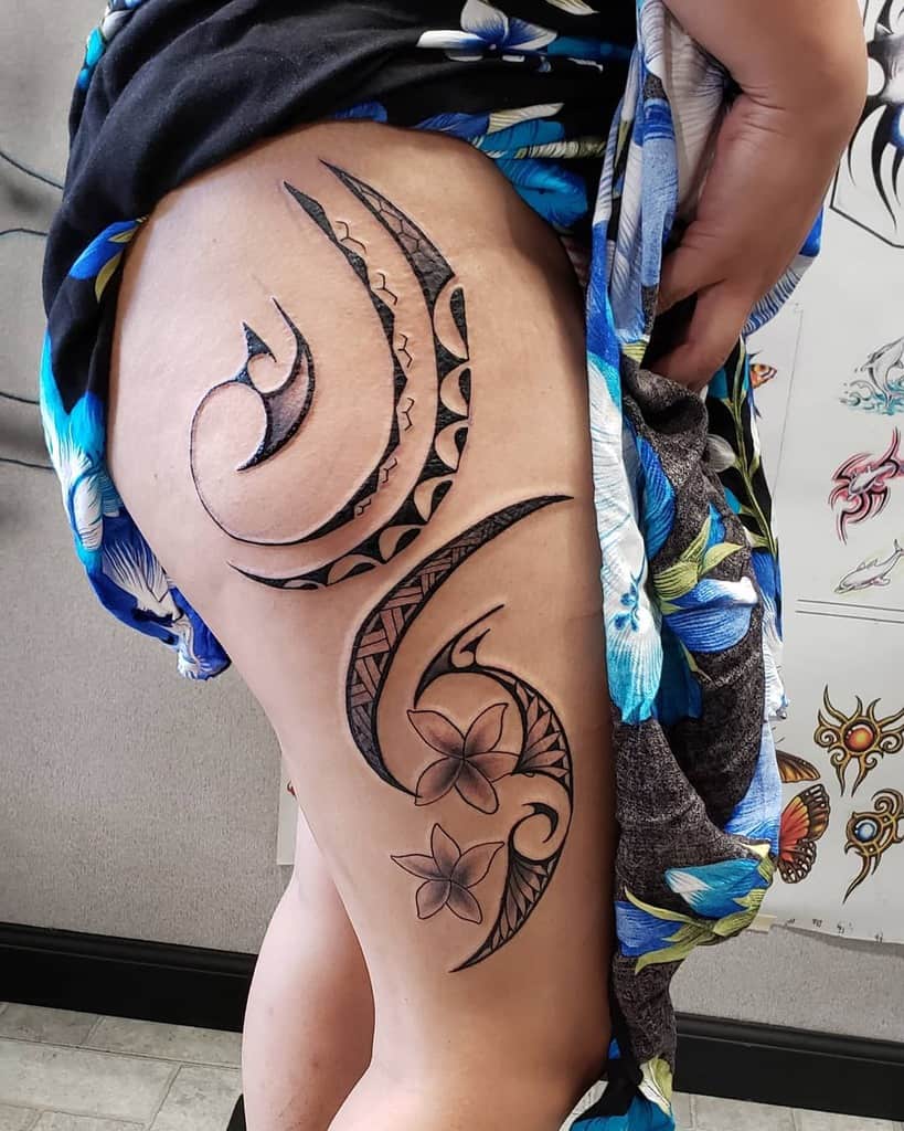 A woman with a floral and abstract pattern tattoo on her thigh