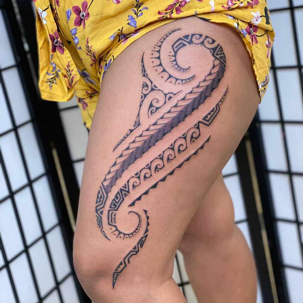 Intricate tribal tattoo with swirls on a woman's thigh