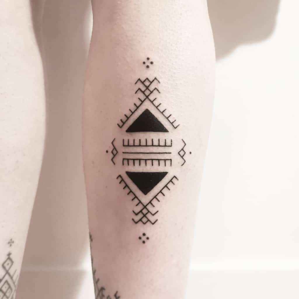 Geometric tattoo with triangles and zigzag patterns on a calf