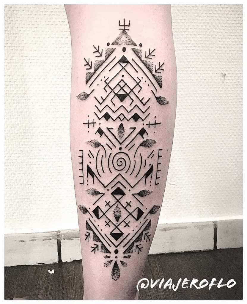Geometric tribal tattoo on a calf featuring symmetrical patterns, dots, and lines