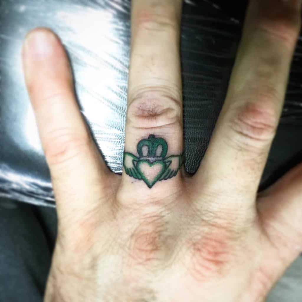 Tattoo of a Claddagh ring, featuring a heart with a crown and two hands holding it