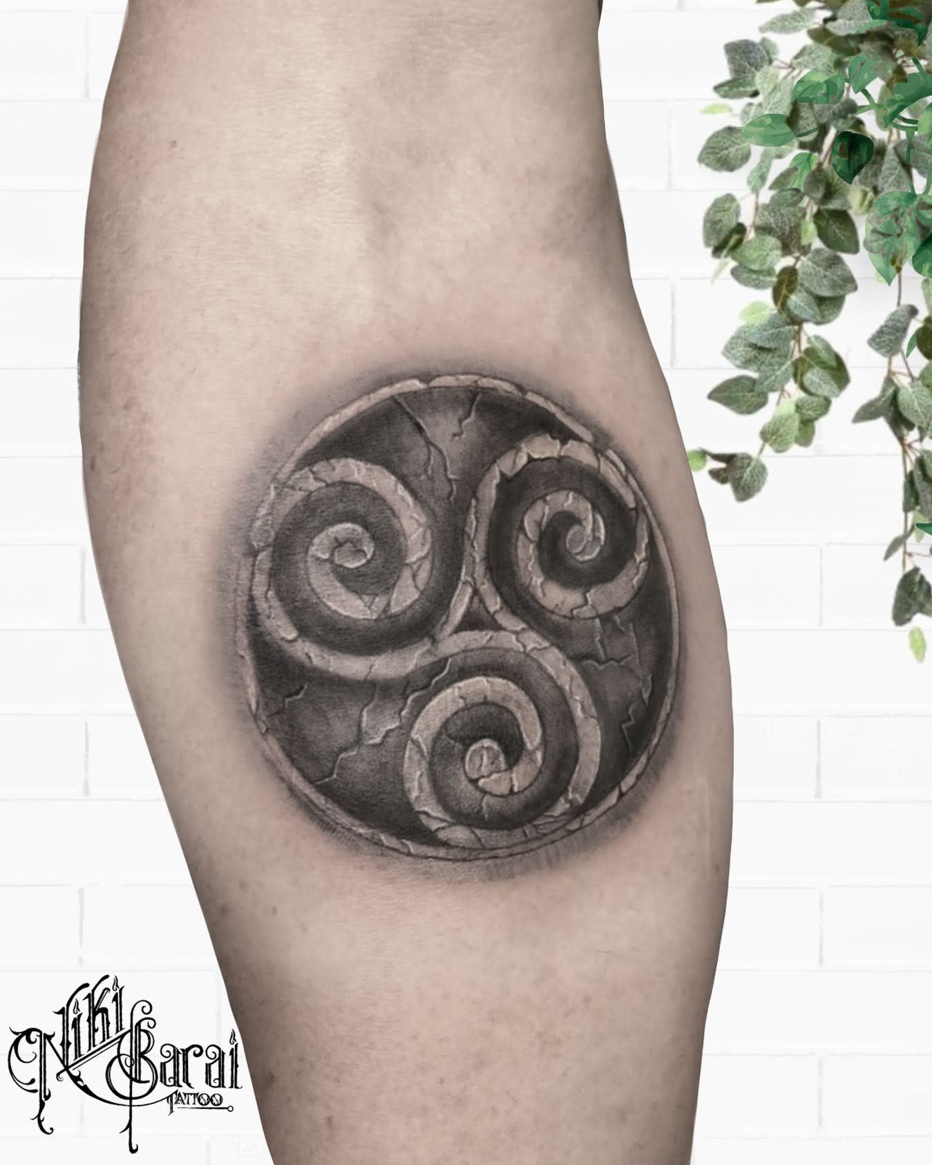 Leg tattoo of a stone-like Celtic Triskelion symbolizing ancient wisdom and resilience