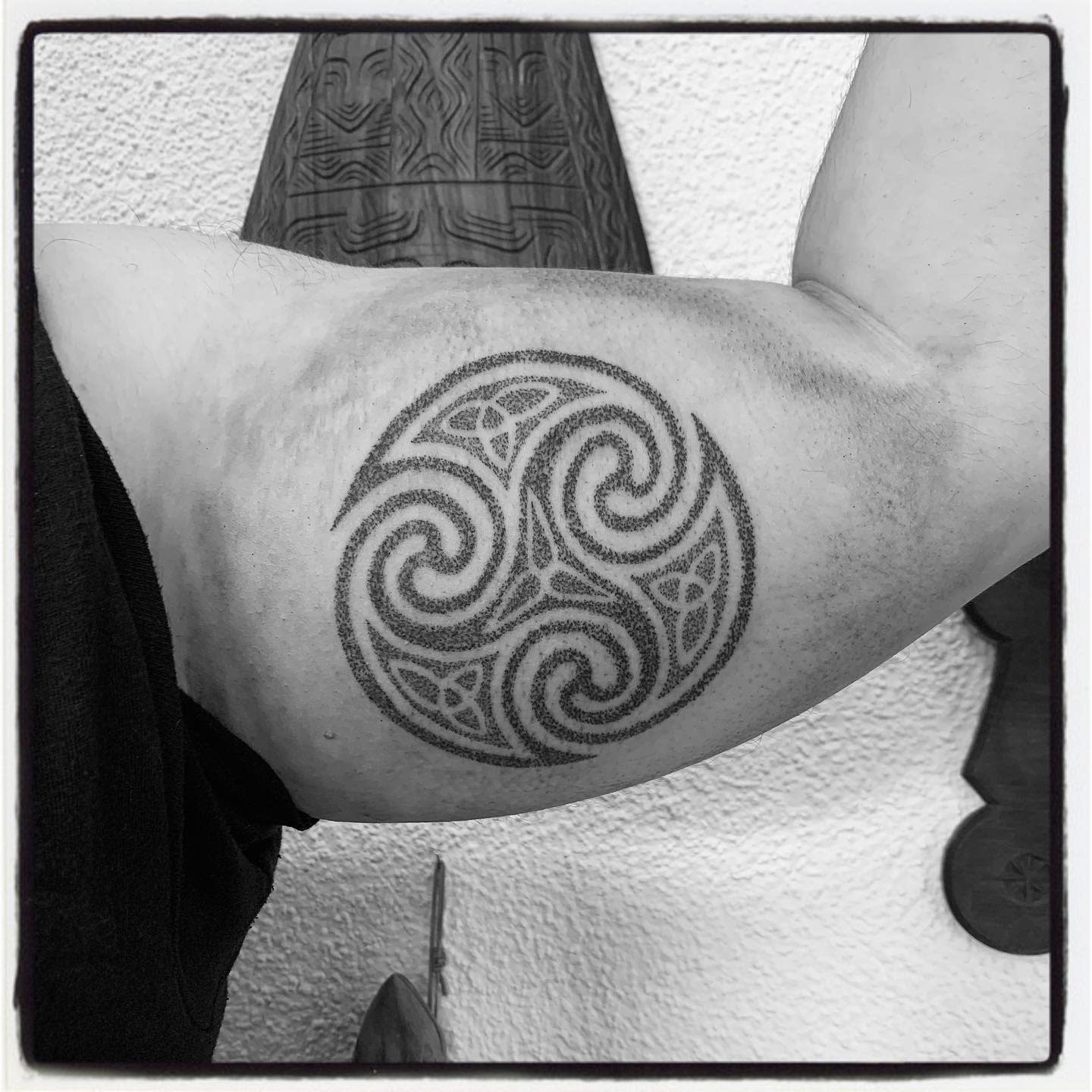 Bicep tattoo featuring a detailed Celtic Triskelion, representing cycles and interconnectedness