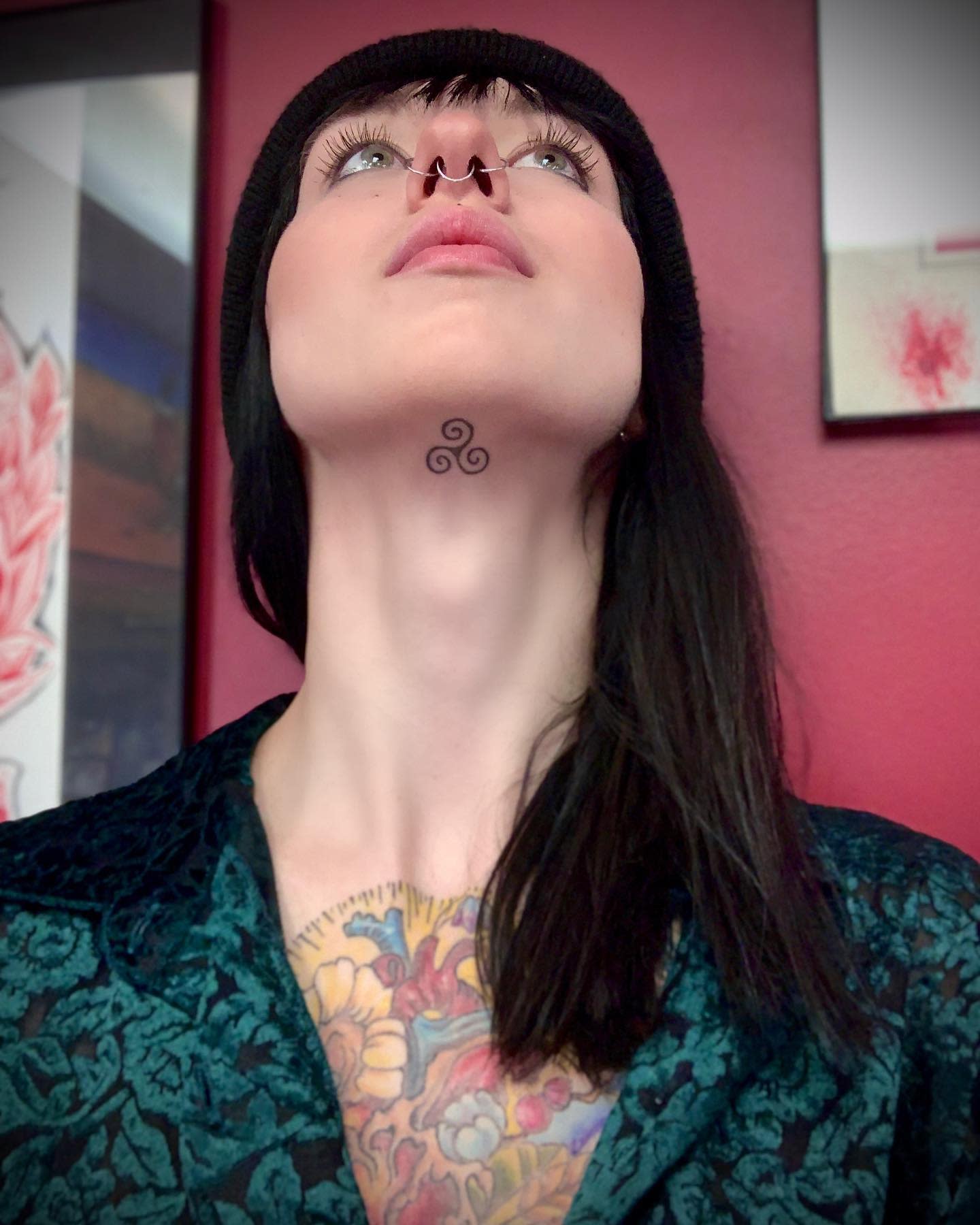 Under-chin tattoo of a minimalist Triskelion symbolizing spiritual growth and unity