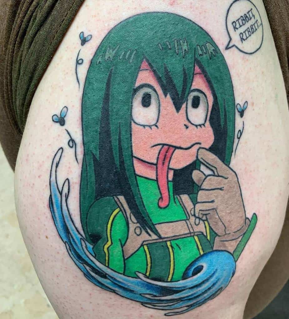 Colorful tattoo of Tsuyu Asui from My Hero Academia, sticking out her long tongue with water effects, flies, and a speech bubble saying 'Ribbit, Ribbit'