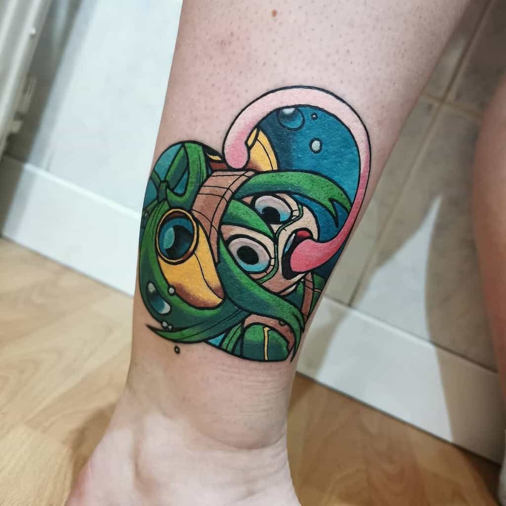 Vibrant tattoo of Tsuyu Asui from My Hero Academia, with her frog-like features, large goggles, and extended tongue, surrounded by bubbles