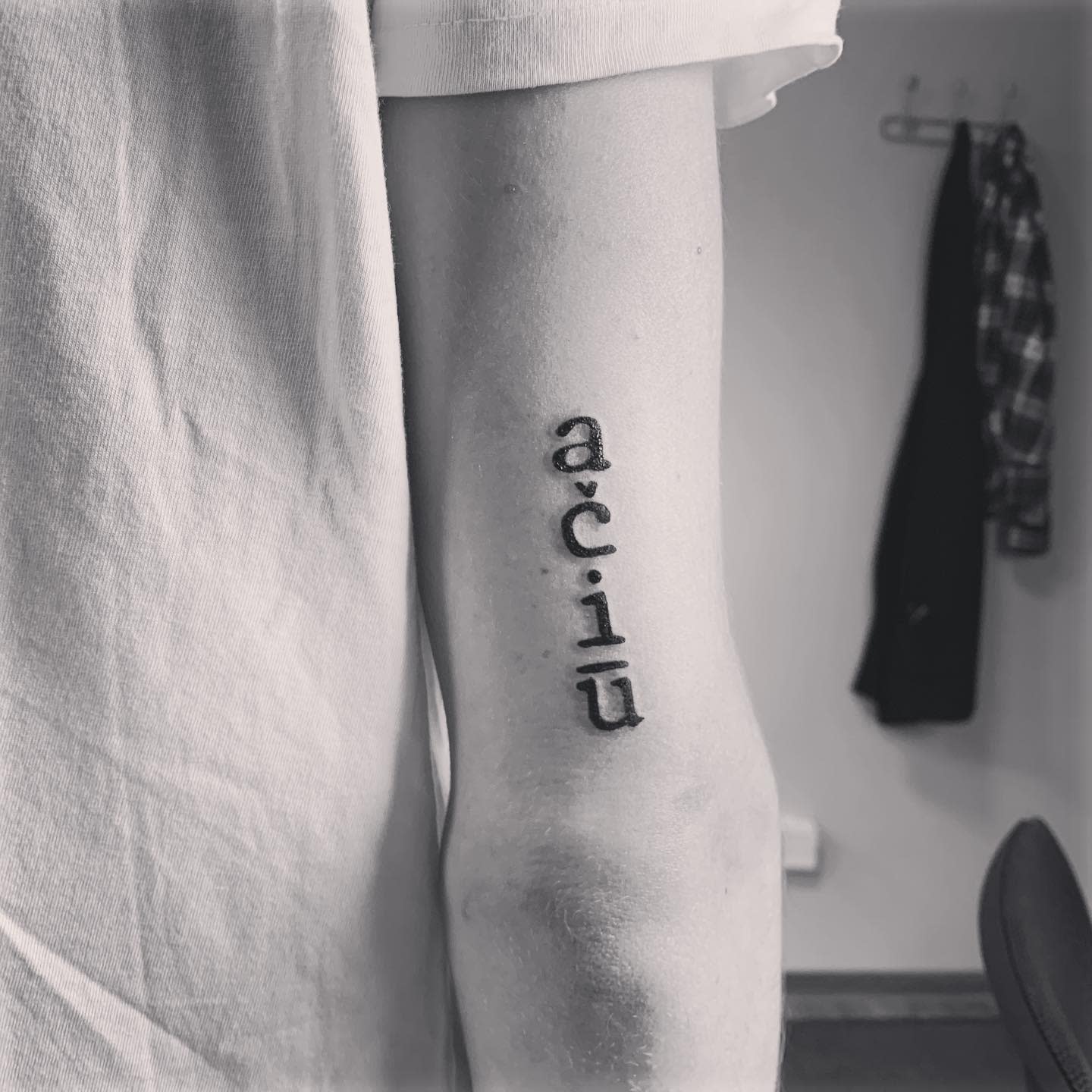 Tattoo of the word "ačiū" on an arm