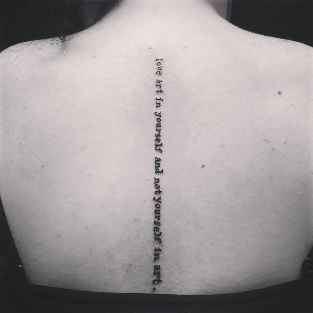 Tattooed quote in black ink along their spine: "love art in yourself and not yourself in art"