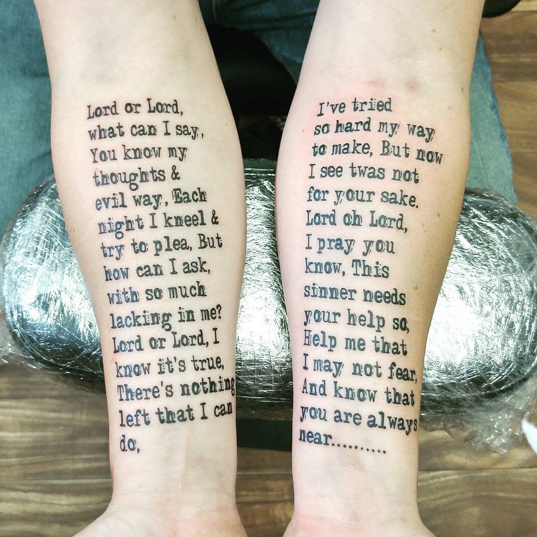 Two forearms with religious text tattoos facing upwards
