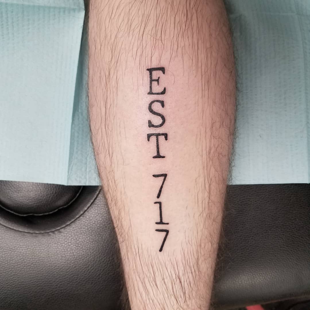 Tattoo of "EST 717" on a leg