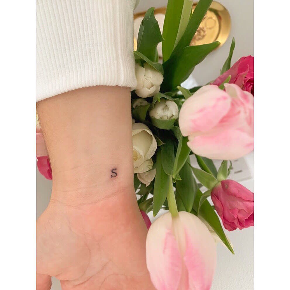 Wrist with a small "S" tattoo 