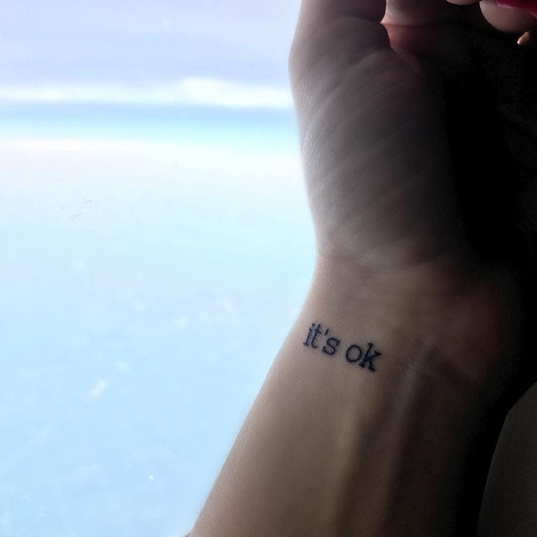 Tattoo on a wrist that says "it's ok"