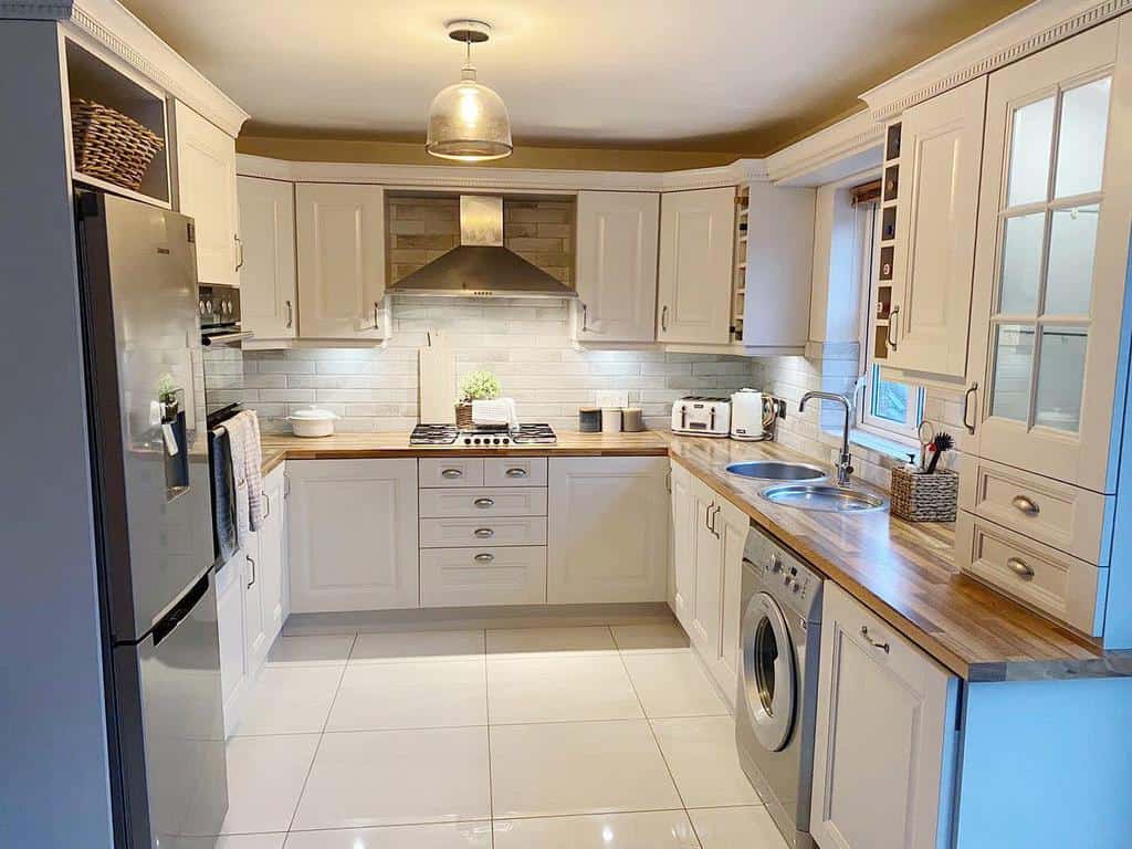 country style kitchen with white cabinets and wood countertop