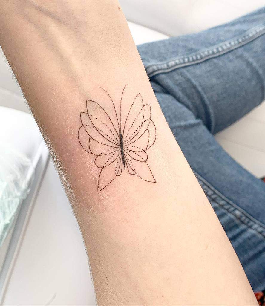 Minimalist butterfly tattoo on a forearm