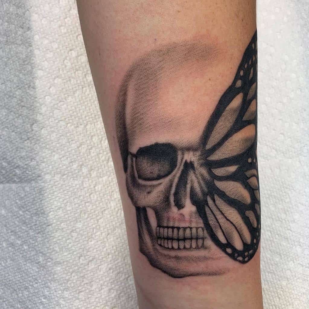 A tattoo of a skull with a butterfly wing on half of its face