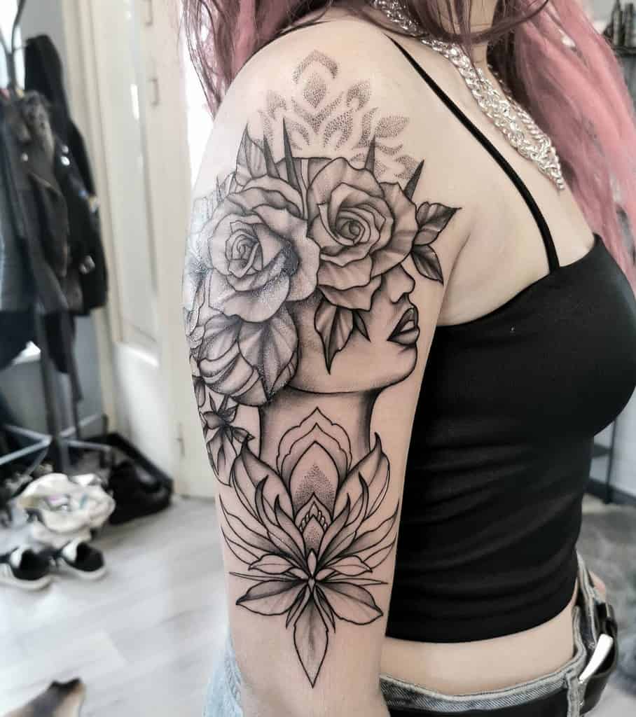 Arm tattoo of a woman's profile with roses and geometric designs in black ink