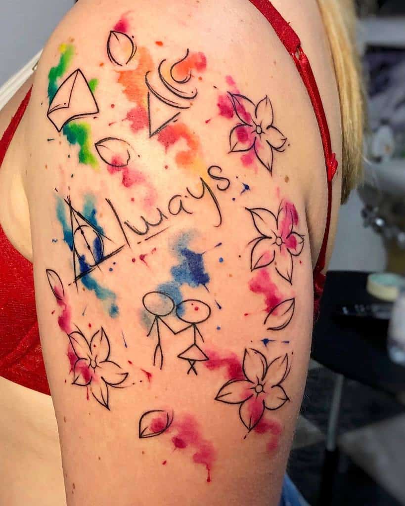 Watercolor tattoo on upper arm featuring symbols, flowers, and the word "Always"