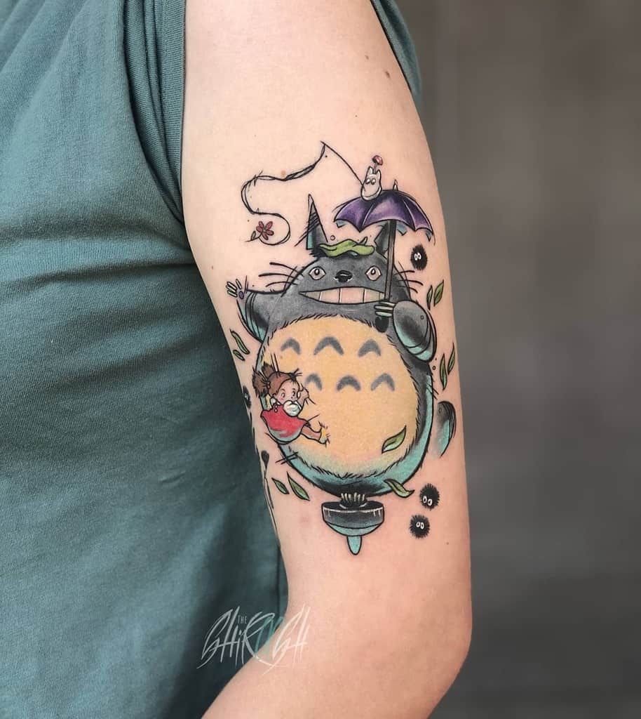 Upper arm tattoo featuring a colorful and whimsical scene, inspired by beloved animated characters, with fine line details and playful elements