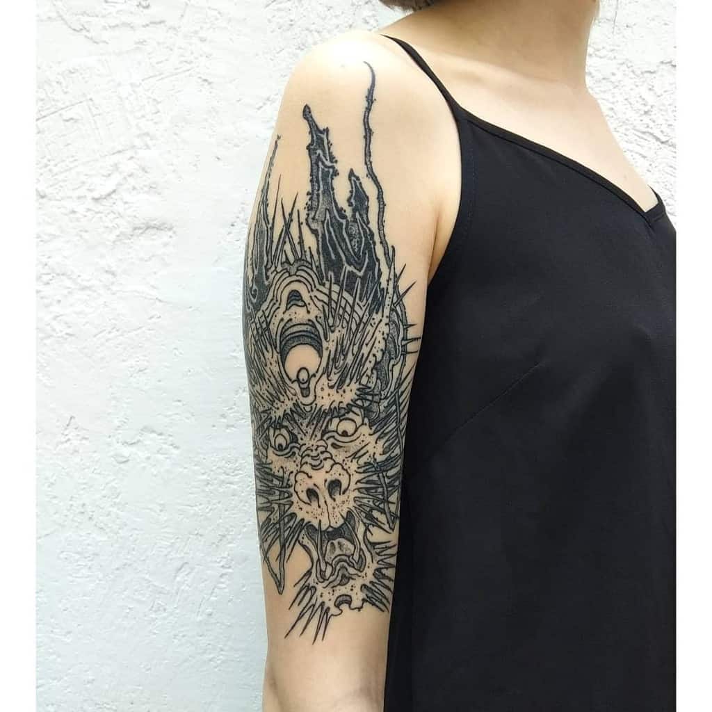 A woman with a detailed dragon tattoo on her upper arm