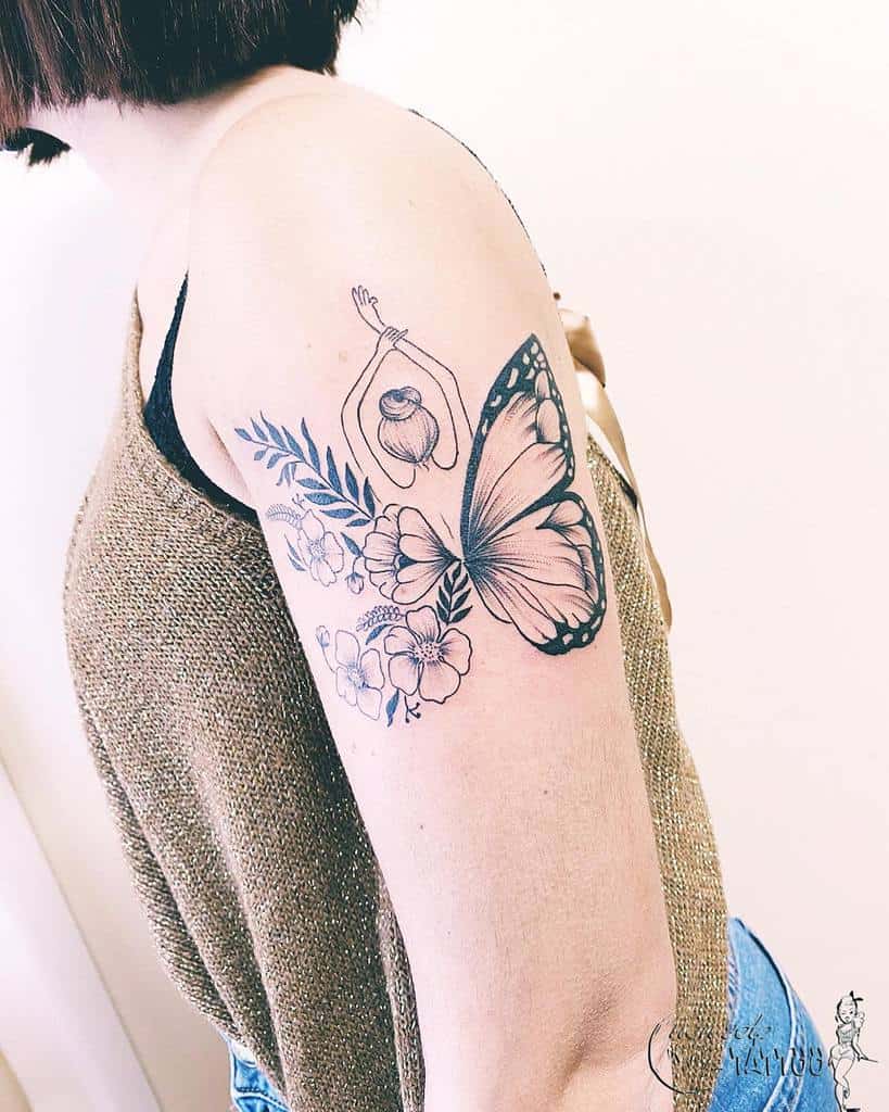 A tattoo of a butterfly, flowers, and a figure on a woman's upper arm