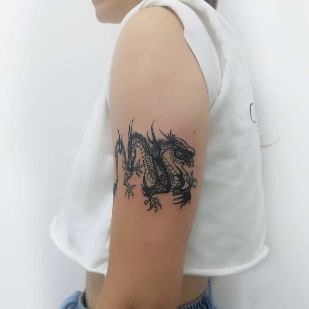 Tattoo of a dragon on a woman's upper arm