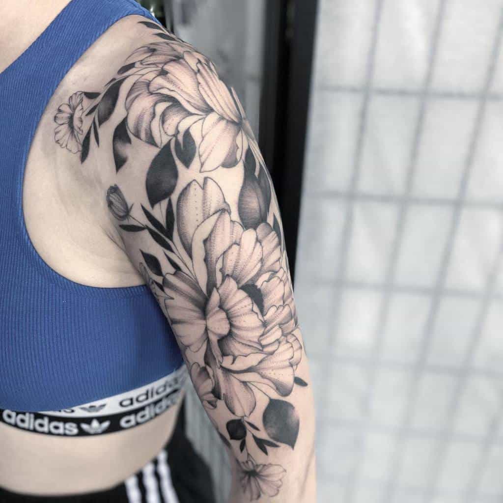 Intricate floral sleeve tattoo on an upper arm
