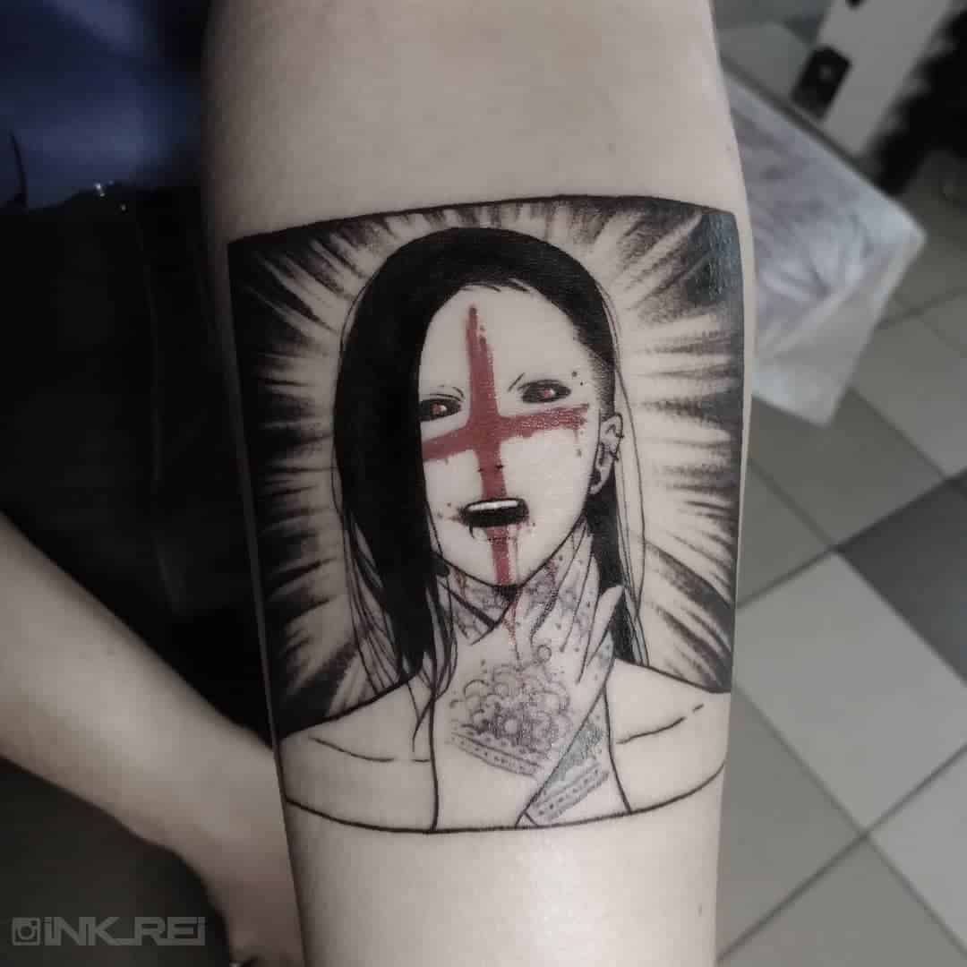 A black and grey tattoo featuring Uta from Tokyo Ghoul, with a red cross painted across his face, radiating dark energy with intricate details