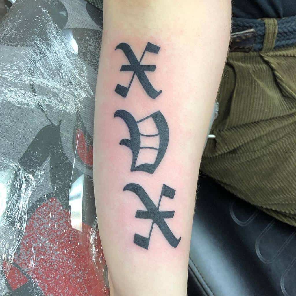 Black ink straight edge XVX tattoo, three symbols stacked vertically