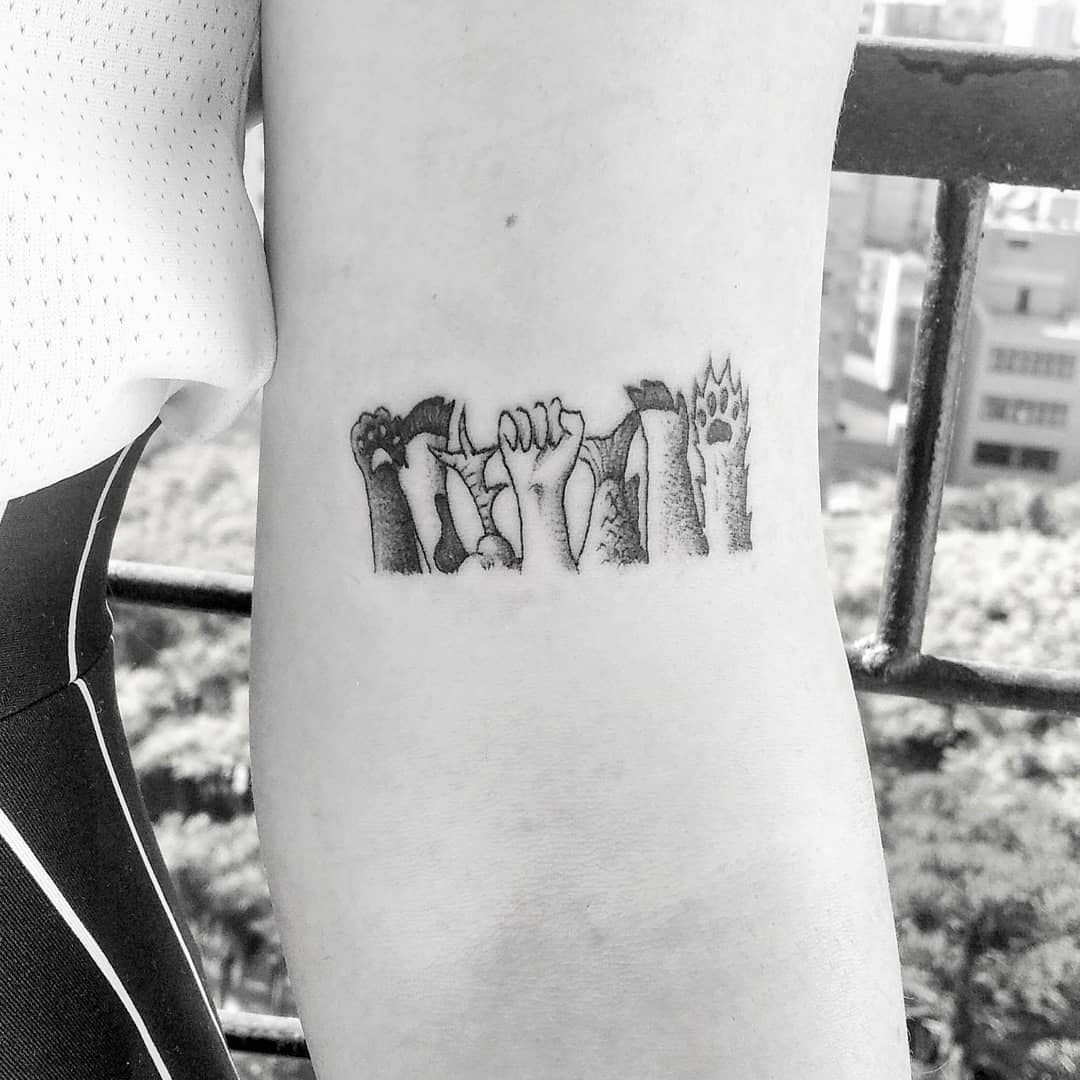 Tattoo of animal paws inlcuding human arm