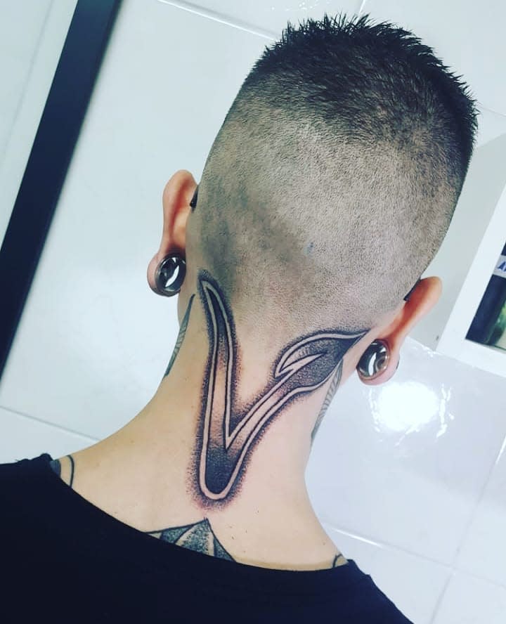 Large, intricate V tattoo extending from the neck to the scalp