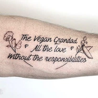 Tattoo of text "The Vegan Grandad, All the love without the responsibilities" surrounded by vegetables