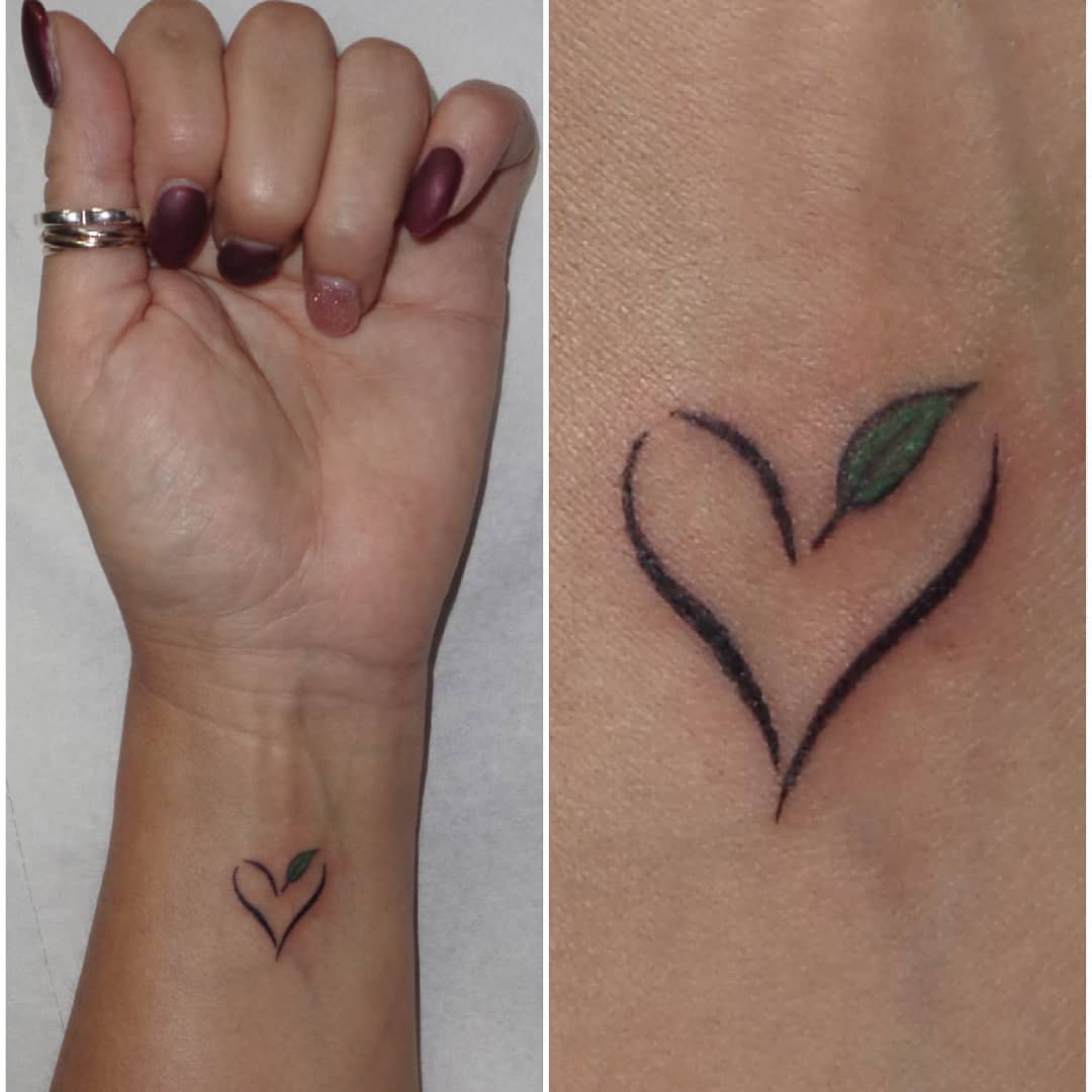 Heart tattoo with a green leaf on a wrist