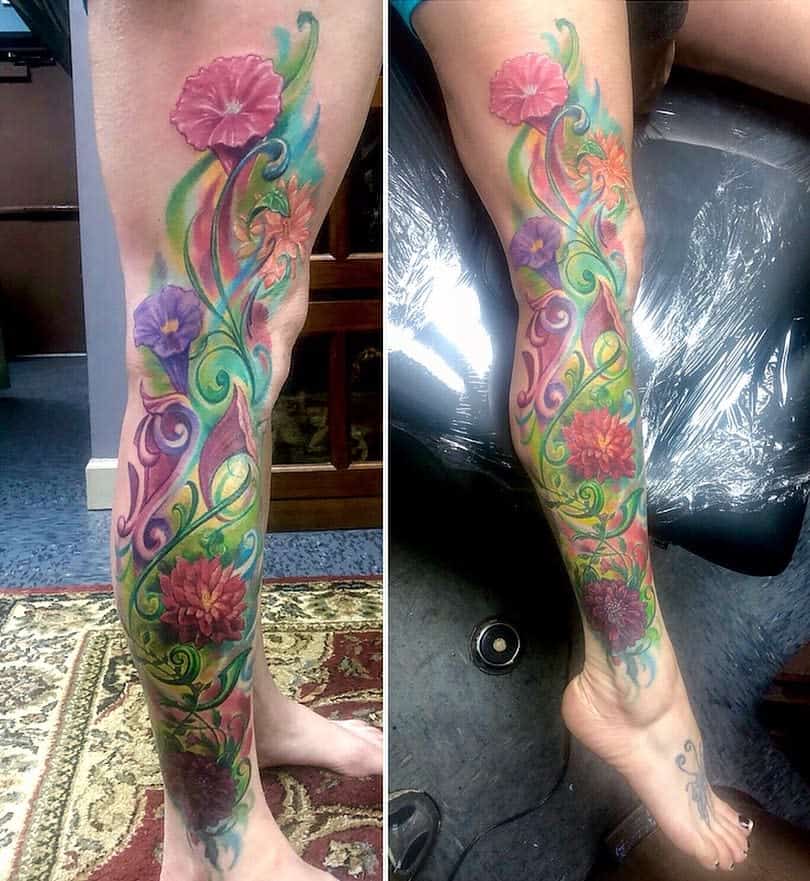 A vibrant floral tattoo sleeve elegantly spirals around a leg