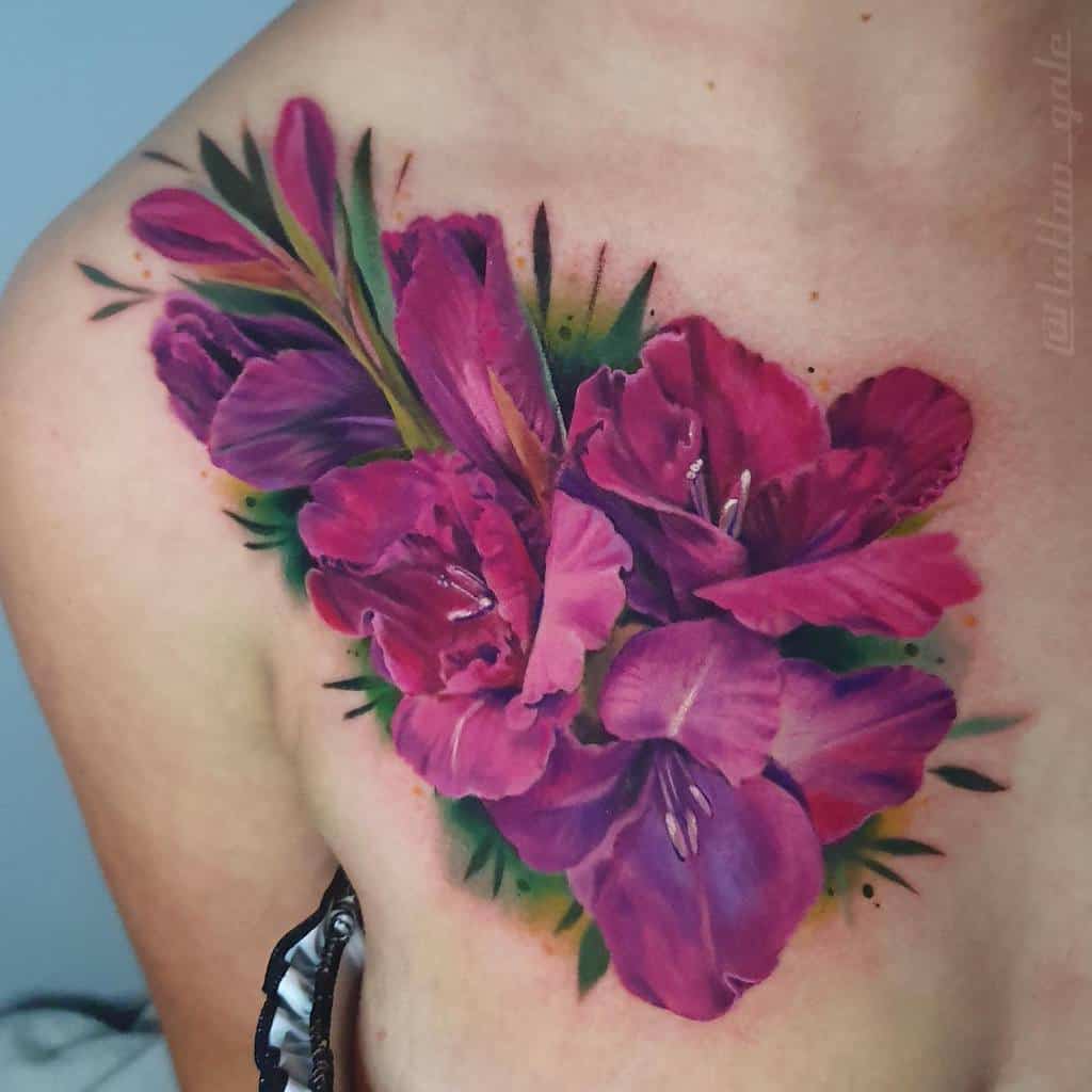 A vibrant tattoo of purple and pink gladiolus flowers adorns a person's upper chest and shoulder