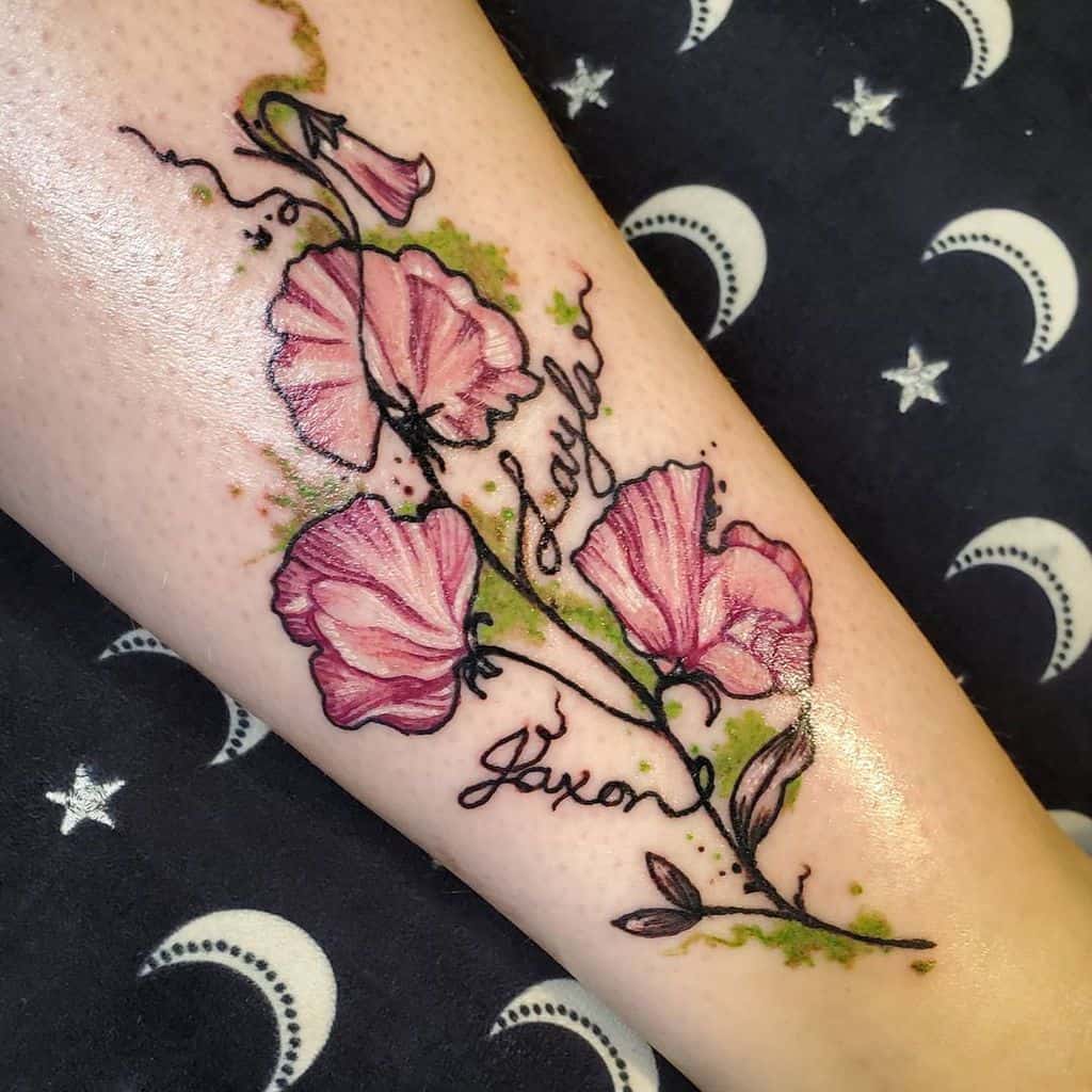 Watercolor sweet pea flower tattoo featuring soft pink petals with names "Layla" and "Jaxon" intertwined in the design. The green watercolor accents add a natural touch, flowing alongside the delicate vine.
