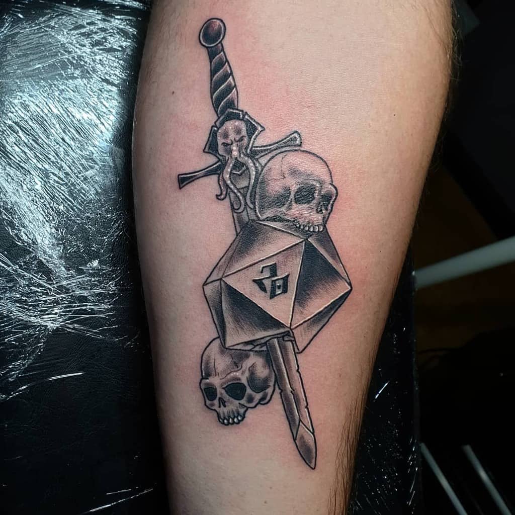 Dark fantasy Dungeons & Dragons tattoo featuring a d20 die, skulls, and a dagger with a Mind Flayer hilt, symbolizing danger and fate