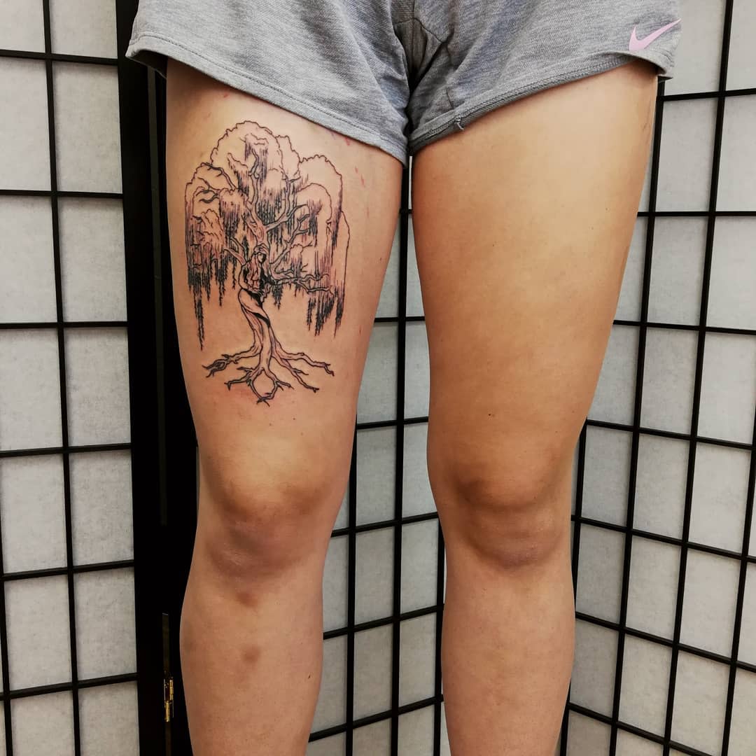 Tattoo of a weeping willow tree on a thigh