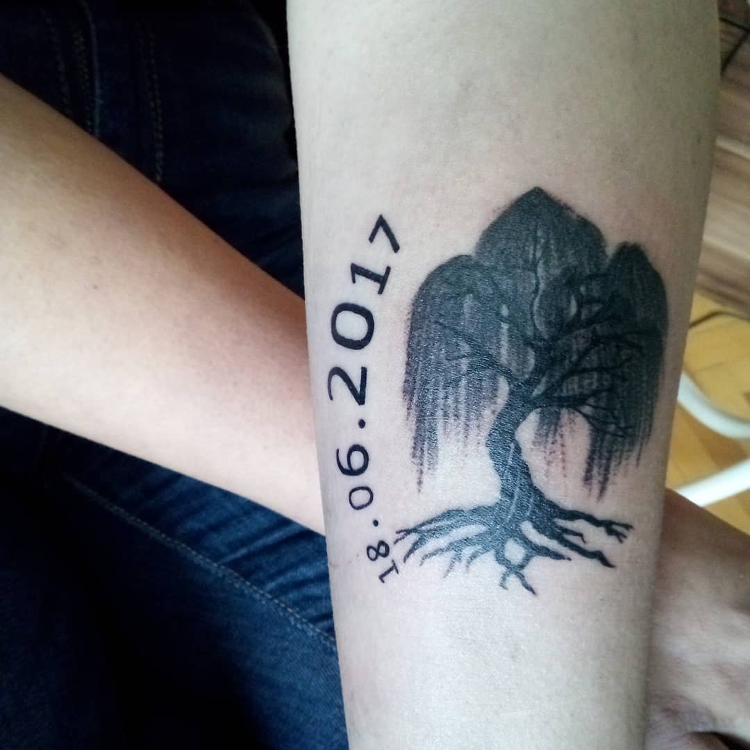 Tattoo of a willow tree and date "18.06.2017" on a forearm