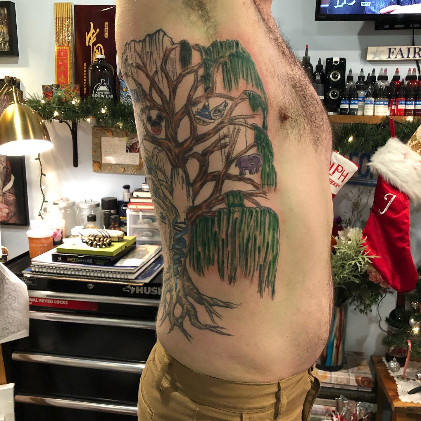 A man with a large willow tree tattoo on his side