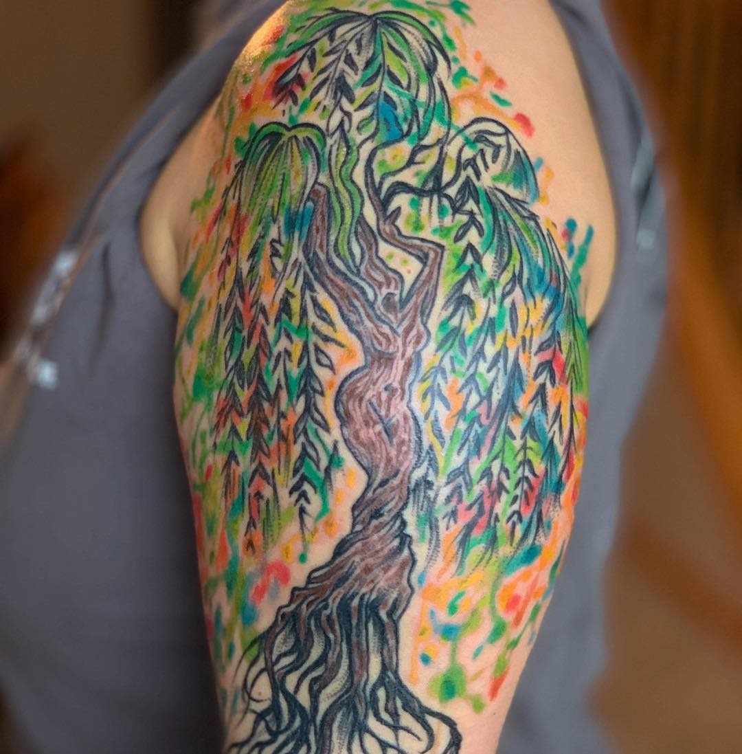 Colorful tattoo of a willow tree on an upper arm