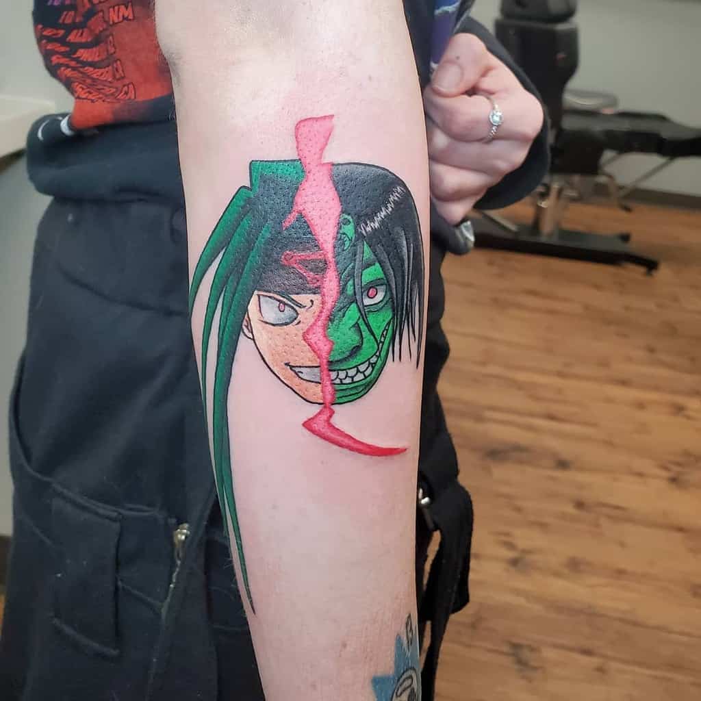 Fullmetal Alchemist tattoo of Envy, split down the middle, showing both human and monstrous forms and a red dividing slash
