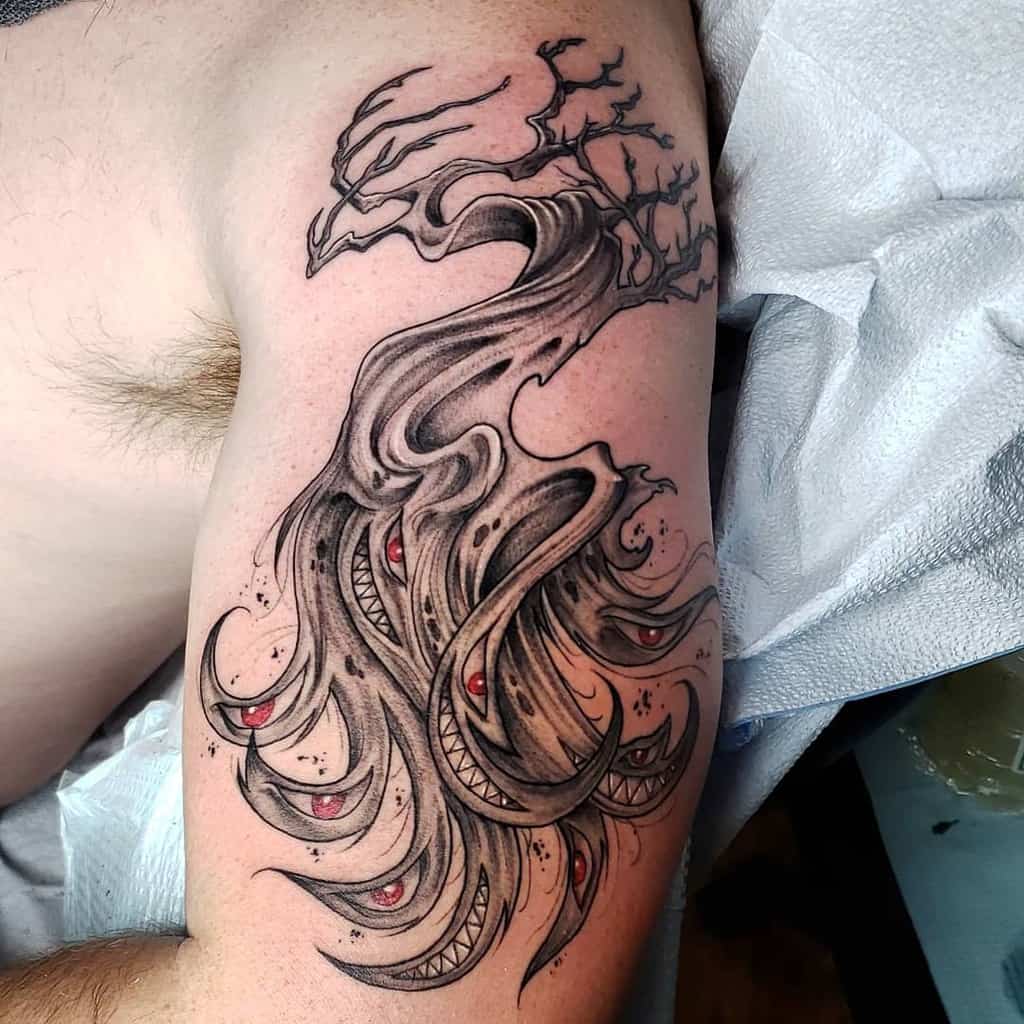 Fullmetal Alchemist tattoo of a dark, twisted tree merging into a mass of writhing shadows with red eyes and sharp-toothed mouths, resembling Pride's shadow